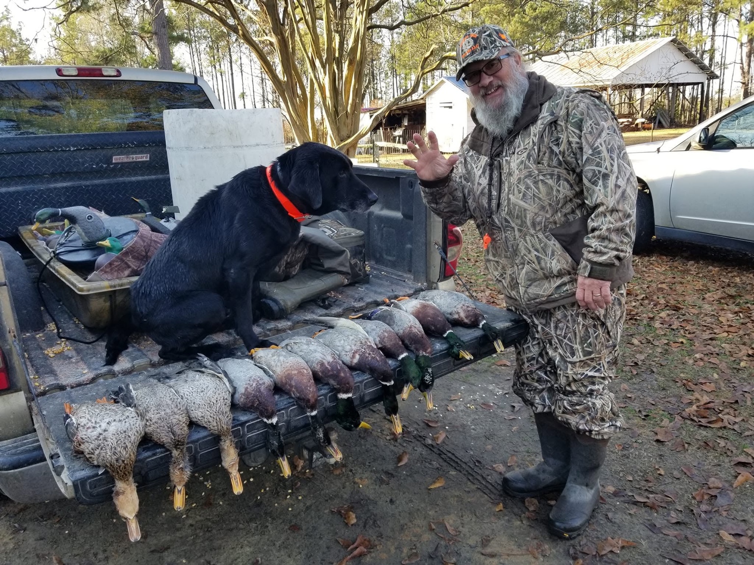 Clay Hasty with a dog and ducks after field work