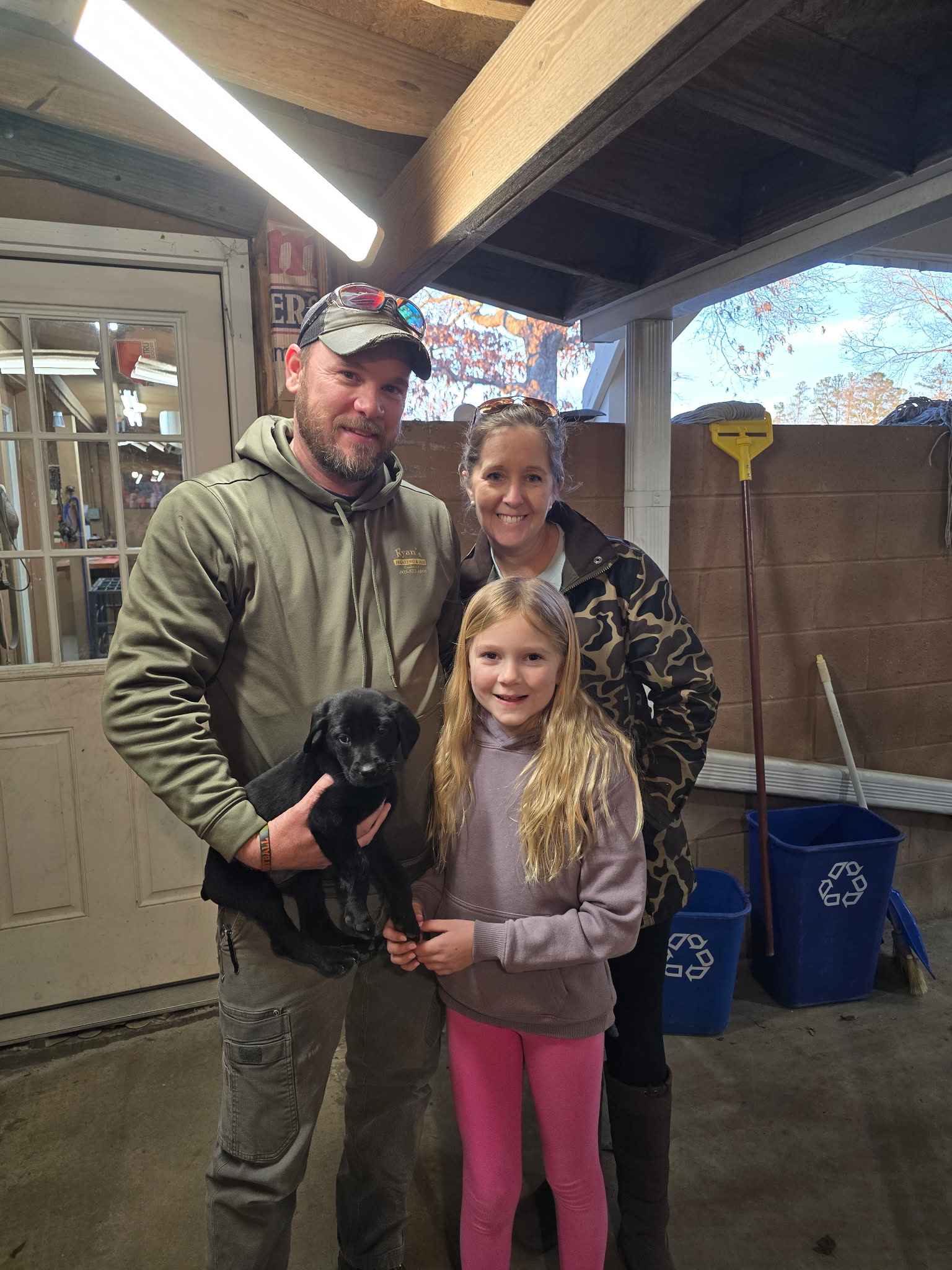 Family holding a black Labrador puppy at Seegars Mill Kennels